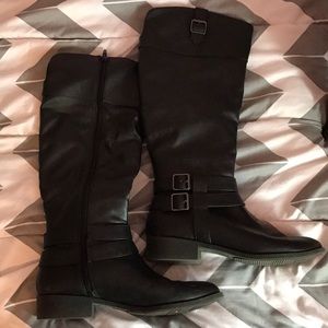 Black knee-high zip up boots.